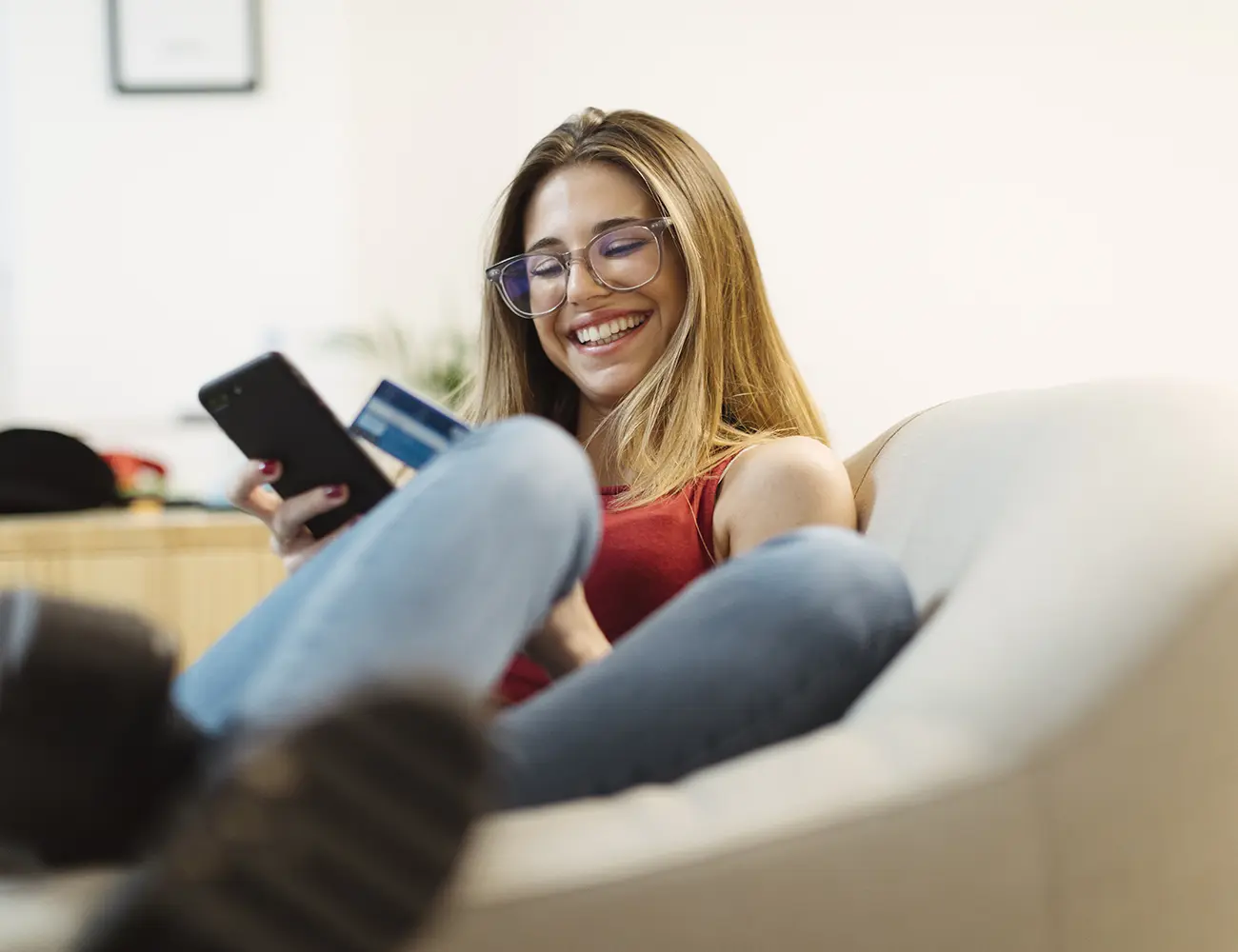girl holding phone sitting on couch